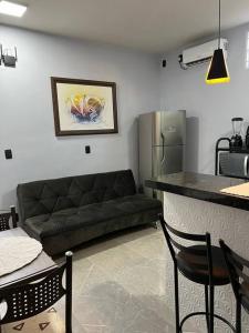 ein Wohnzimmer mit einem Sofa und einer Küche in der Unterkunft Kitnet Cidade de Goiás - Go #02 in Goiás