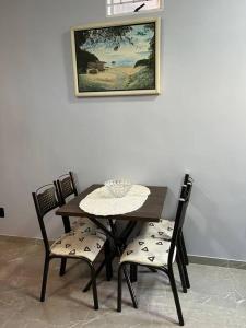 mesa de comedor y sillas con una foto en la pared en Kitnet Cidade de Goiás - Go #02 en Goiás