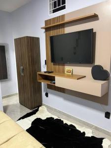ein Wohnzimmer mit einem Flachbild-TV an der Wand in der Unterkunft Kitnet Cidade de Goiás - Go #02 in Goiás