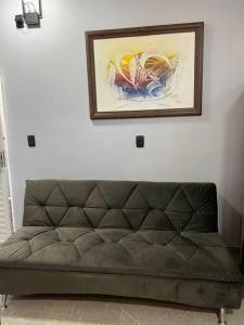 a couch in a room with a painting on the wall at Kitnet Cidade de Goiás - Go #02 in Goiás