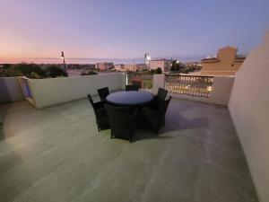 patio con mesa y sillas en el balcón en رويال فيلا بمسبح خاص en King Abdullah Economic City