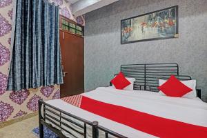 a bedroom with a bed with red pillows at OYO Flagship MH Palace in Lucknow