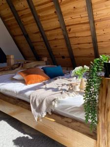 Bett in einem Holzzimmer mit Pflanzen darauf in der Unterkunft Sapancamtbungalov in Sapanca