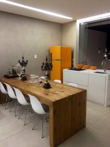 a kitchen with a wooden table and white chairs at Apartamento Cobertura inteiro em BH in Belo Horizonte