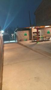 een gebouw met twee picknicktafels en groene parasols 's nachts bij Santa Matilde Hospedaje in Malargüe +14 foto's