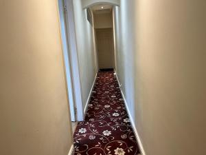 a long hallway with a red carpet in a building at Amazing Entire Home in WOLVERHAMPTON in Wolverhampton