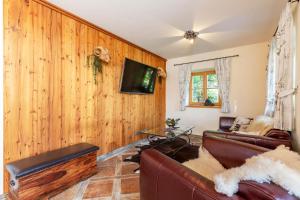 a living room with a couch and a tv on a wall at Chalet unter weiß-blauem Himmel in Reit im Winkl