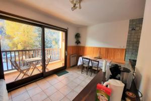 cocina con balcón con mesa y sillas en Joli nid de ski à La Salle-les-Alpes, en La Salle-les-Alpes