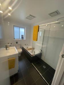 a bathroom with a shower and a toilet and a sink at Inner City Boutique Home. Pet and Family Friendly! in Canberra