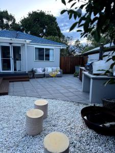 a backyard with three stools in front of a house at Inner City Boutique Home. Pet and Family Friendly! in Canberra