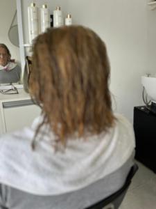 a woman with long hair looking in a bathroom mirror at Casinha na praia in Imbé