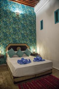 Un dormitorio con una cama con toallas azules. en Riad Merzouga en Fez
