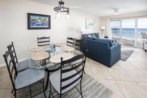ein Wohnzimmer mit einem Tisch, Stühlen und einem Sofa in der Unterkunft Gulf Dunes 312 by Brooks and Shorey Resorts condo in Fort Walton Beach