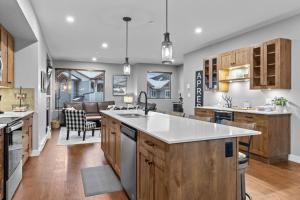 an open kitchen with wooden cabinets and a dining room at Echo Landing #42 by Bear Country in Sun Peaks