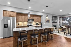 a kitchen with a large island with bar stools at Echo Landing #42 by Bear Country in Sun Peaks