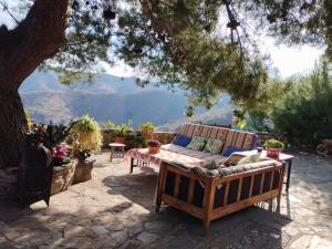 kanapę siedzącą na patio pod drzewem w obiekcie Pinar El Almendra w Maladze