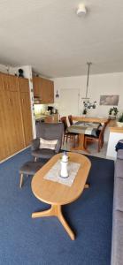 uma sala de estar com mesa e cadeiras e uma cozinha em Knechtsand 402 em Cuxhaven