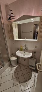ein Badezimmer mit einem Waschbecken, einem WC und einem Spiegel in der Unterkunft Knechtsand 402 in Cuxhaven