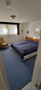 ein Schlafzimmer mit einem Bett und einem blauen Teppich in der Unterkunft Knechtsand 402 in Cuxhaven