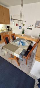 eine Küche mit einem Tisch und Stühlen sowie ein Esszimmer in der Unterkunft Knechtsand 402 in Cuxhaven