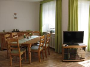 杜能的住宿－Ernst-Gock Weg 07，一间带桌子和电视的用餐室