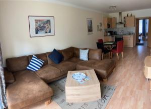 - un salon avec un canapé brun et une table dans l'établissement Oasis 03, à Cuxhaven