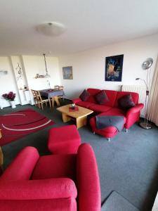 ドゥネンにあるResidenz 08のリビングルーム(赤いソファ、テーブル付)