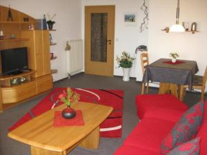 ドゥネンにあるResidenz 08のリビングルーム(赤いソファ、テーブル付)