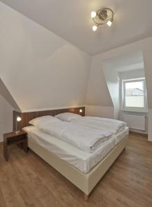 um quarto com uma grande cama branca e uma janela em Op de Geest 15 em Cuxhaven