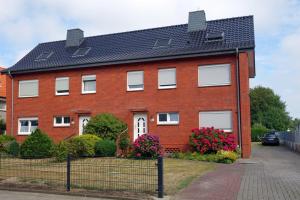 une maison en briques rouges avec un toit noir dans l'établissement Rugenbargsweg 29 Whg 1, à Duhnen