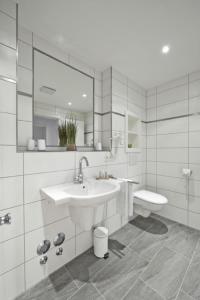 een witte badkamer met een wastafel en een toilet bij Op de Geest 16 in Cuxhaven