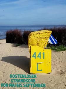 a yellow table and chair on the beach at Haus Kehrwieder Fewo 03 in Cuxhaven