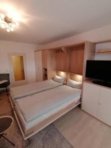 a bedroom with a bed and a flat screen tv at Haus Kehrwieder Fewo 03 in Cuxhaven