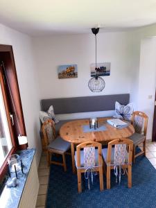 een eetkamer met een houten tafel en stoelen bij Haus Muschelnest in Sahlenburg