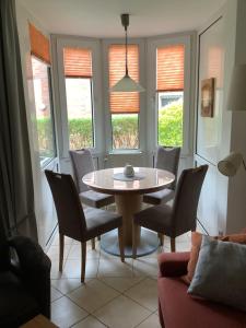 comedor con mesa, sillas y ventanas en Gorch Fock 07, en Duhnen