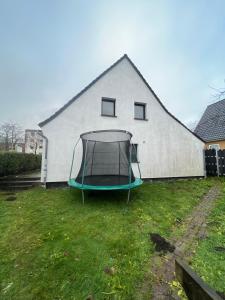 "Live Good, Work Good" Central House by GG Rental Hamburg في Schenefeld: ترامبولين في ساحة بجوار مبنى أبيض