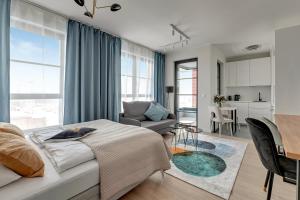 um quarto com uma cama e uma sala de estar em DOKI Apartments by Blue Mandarin em Gdańsk