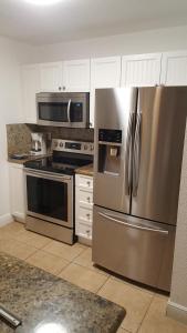 eine Küche mit einem Kühlschrank aus Edelstahl und einer Mikrowelle in der Unterkunft Ocean Villa Supreme in Bailey Town