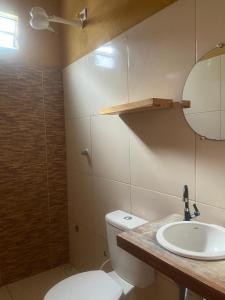 a bathroom with a toilet and a sink and a mirror at Chalé Beach Preá in Prea