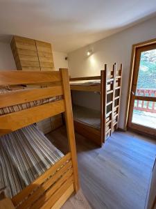 two bunk beds in a room with a window at Chandonnelles 8 in Mussillon