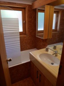 a bathroom with a sink and a tub and a mirror at Chandonnelles 8 in Mussillon +1 photo