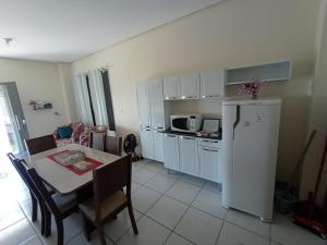 a kitchen and dining room with a table and a refrigerator at Apartamento Aconchego da Serra Azul in Barra do Garças