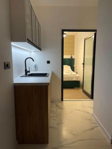 een badkamer met een wastafel en een slaapkamer met een bed bij Apartman Bor in Sokolac