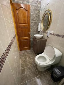 bagno con servizi igienici, lavandino e specchio di Hotel Don Blas Jardín a Jardin