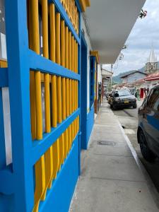 a blue and yellow building with yellow windows on a sidewalk at Hotel Don Blas Jardín in Jardin