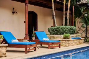 un par de sillones azules junto a una piscina en Hotel Plaza Colon - Granada Nicaragua, en Granada