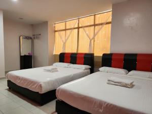 2 camas en una habitación con ventana en Minshu RoomStay en Arau