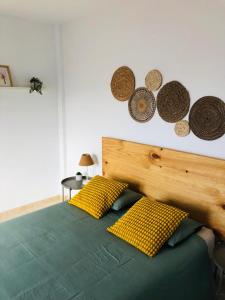 a bed with yellow pillows and hats on the wall at Casa Gara in Yaiza