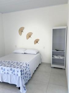 1 dormitorio con 1 cama y 2 sombrillas en la pared en BL Maria Bonita Pousada en Maragogi