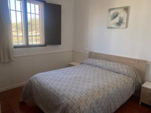 um pequeno quarto com uma cama e uma janela em Cortijo Puente Alhama em Alhama de Granada